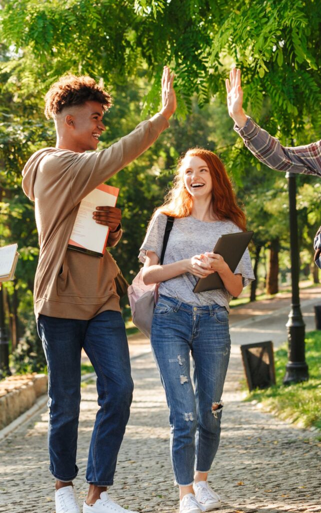 Estudiantes Felices en Malta Estudiantes internacionales sonrientes con libros en Malta, sintiéndose seguros y bienvenidos en su entorno educativo.
