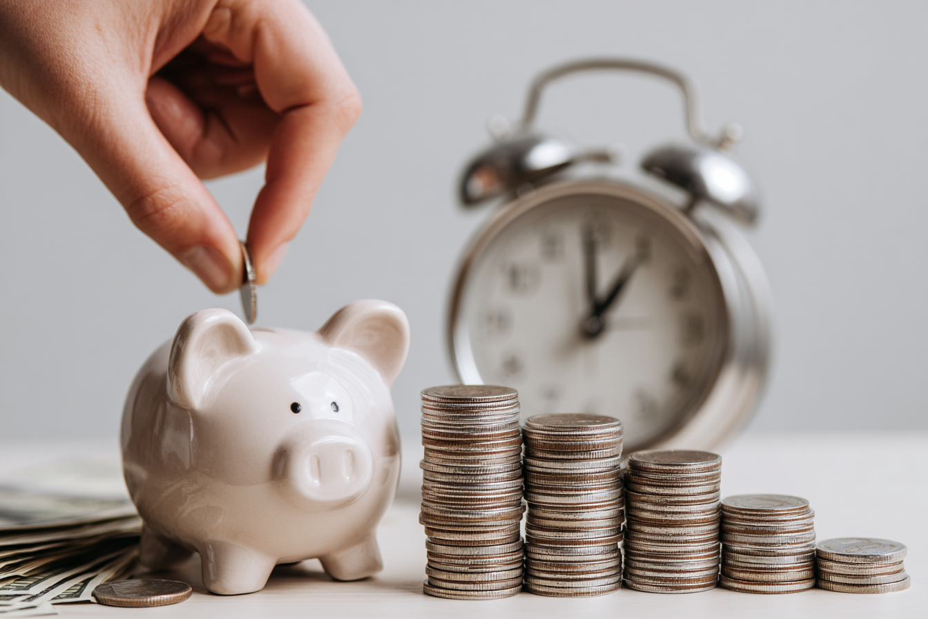 Mano ahorrando monedas en una hucha que representa cuánto cuesta vivir en Malta mientras estudias inglés