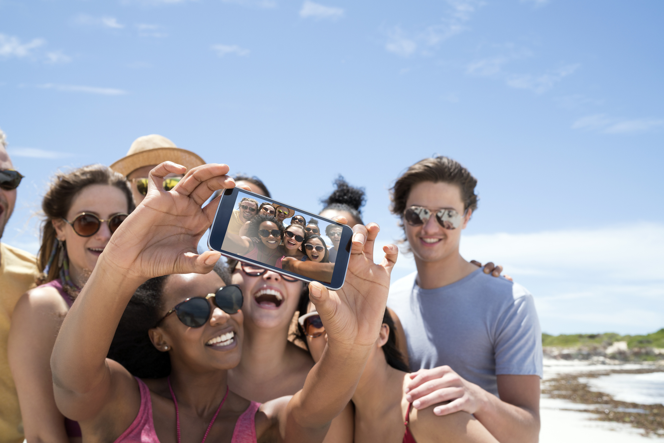 Grupo de estudiantes tomando un selfie en la playa durante sus vacaciones de estudio en Malta, riendo y disfrutando del sol ,planes para estudiantes en Malta.
