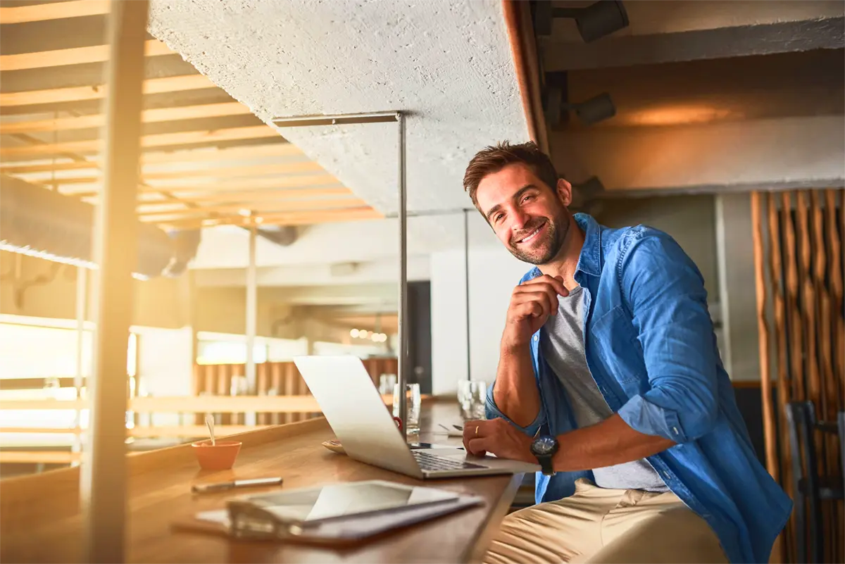Chico con su portátil sonriendo