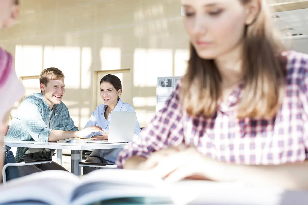 Jóvenes riéndose mientras estudian