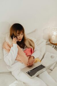 Mujer adulta estudiando inglés con portátiles y libros en un ambiente tranquilo desde casa
